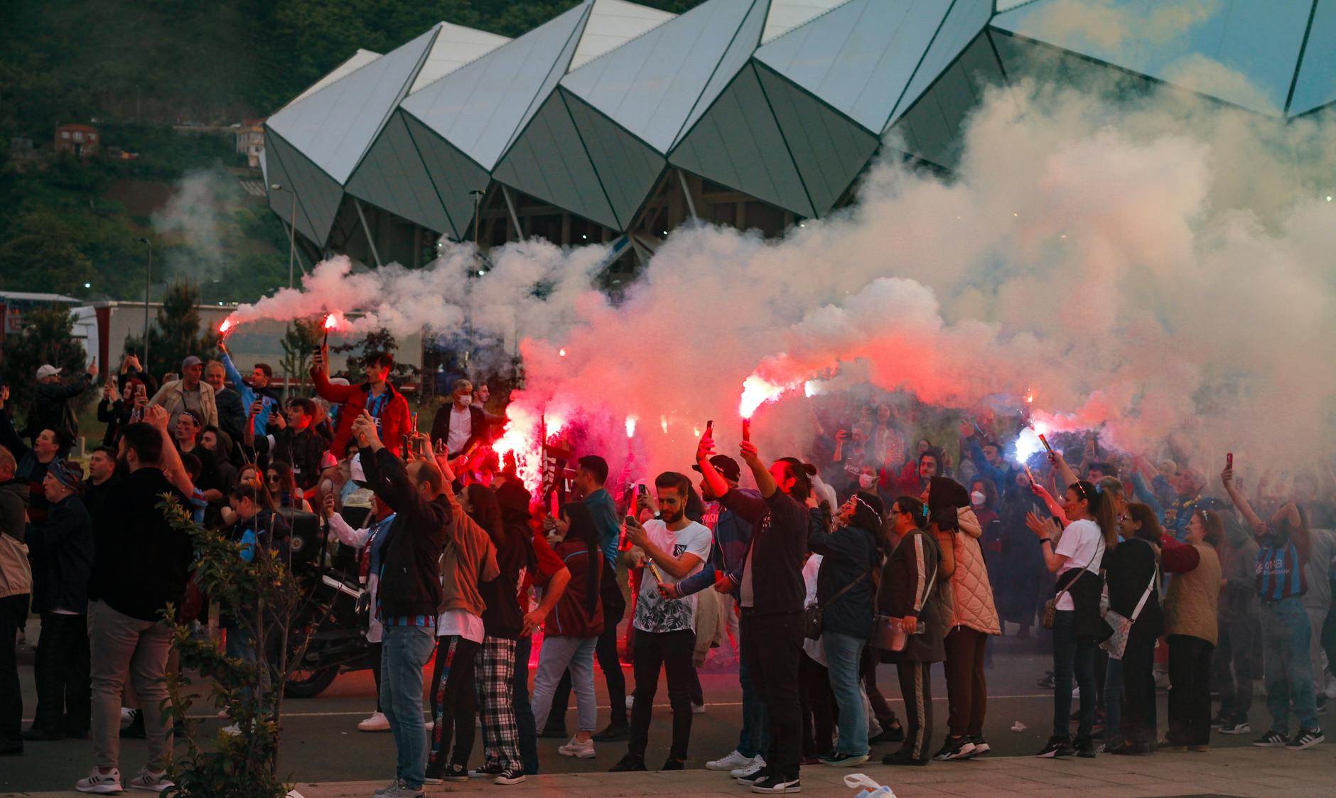soccer fans holding smoke flares